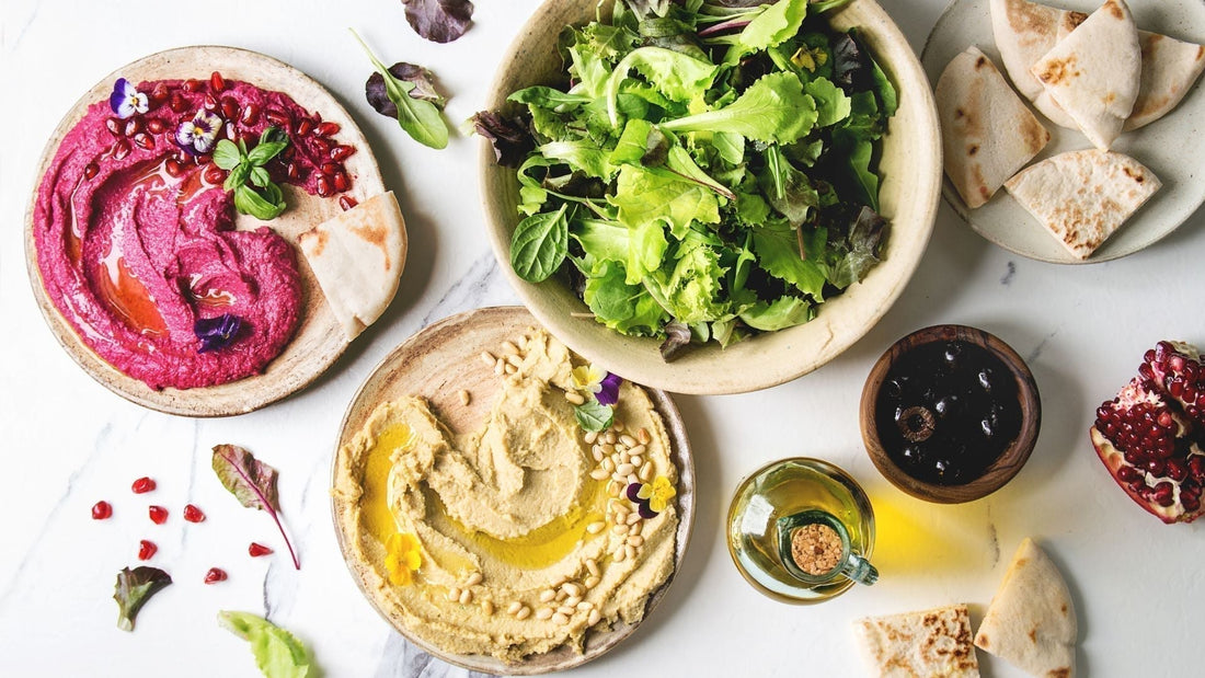 foods to help support the microbiome in particular the Mediterranean diet as shown in the image which shows hummus green leaves olives and olive oil