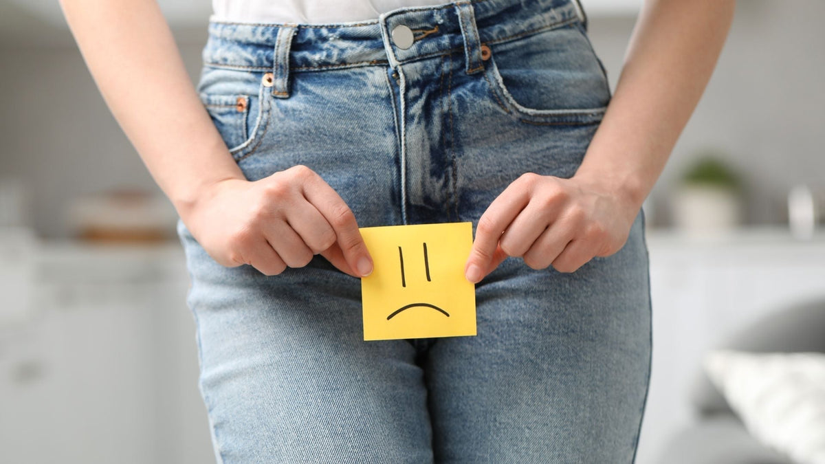 an image of a woman holding a postit with a sad face on it up to her lower body
